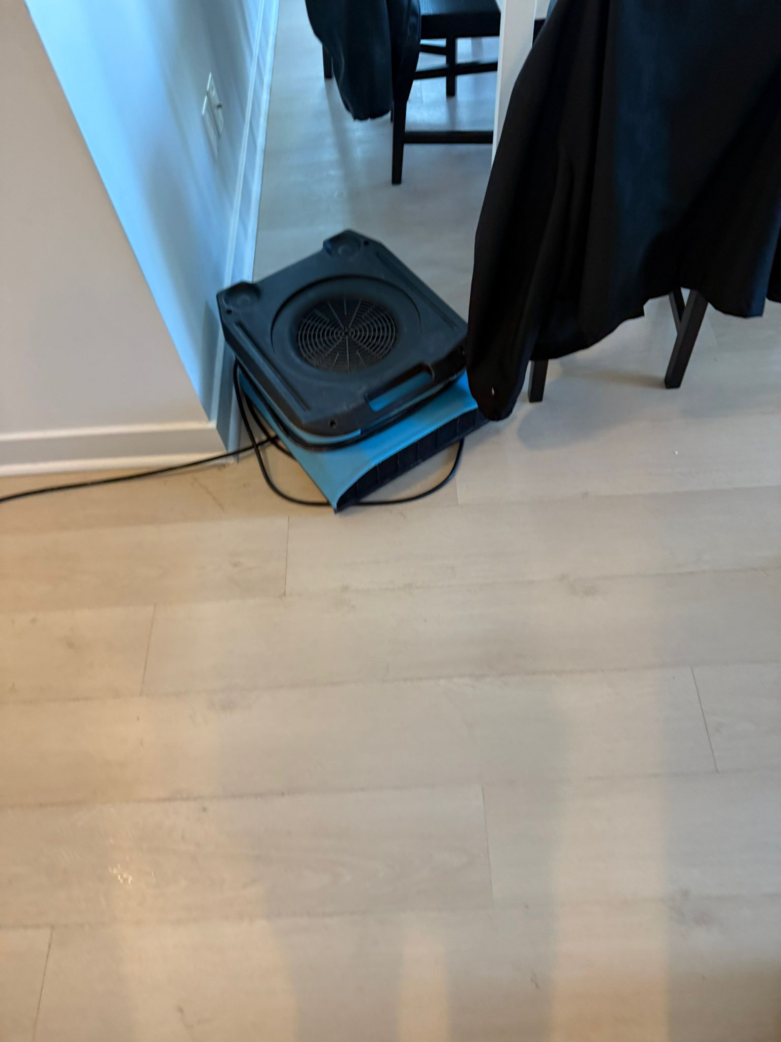 Air movers and dehumidifiers drying water damaged floor